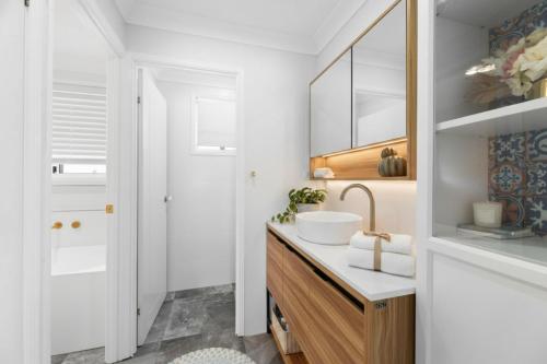 a bathroom with a sink and a mirror at Escape from Relaxing Poolside House 3B in Narellan