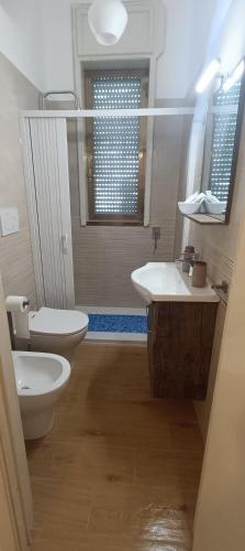 a bathroom with a toilet and a sink and a mirror at Villa Antonietta in Torre Lapillo