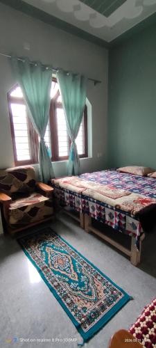 a bedroom with two beds and a rug and windows at Rawat Homestay in Rishīkesh