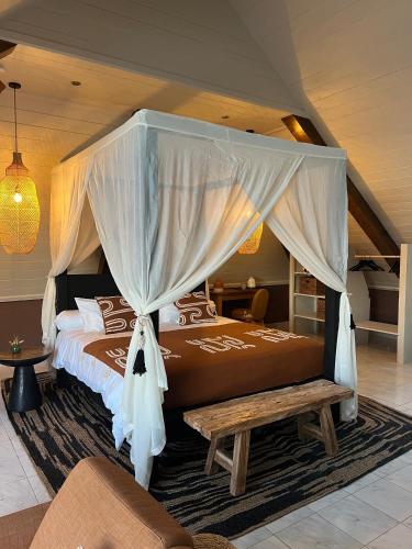 a bedroom with a large bed with a canopy at La Belle du Sud in Saint-Joseph
