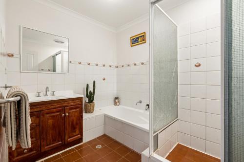 a bathroom with a tub and a sink and a shower at Group stays for Friends Families Weddings and Events Walkable to Fremantle and attractions Super Spacious with garden and courtyard and balcony and parking for 2 cars Sleeps 6 3BD 3BR in Fremantle