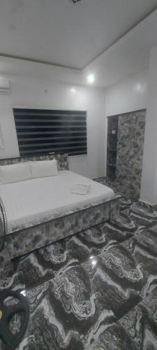 a bedroom with a bed on a rug in a room at Lazeto Hotel and Resorts in Zongon Daji