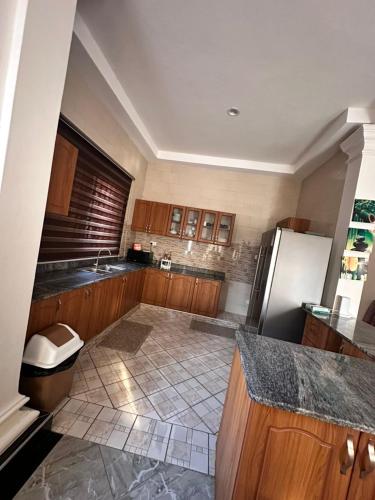 a kitchen with a refrigerator and a tile floor at GRACE ViLLA in Kitende