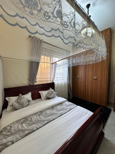 a bedroom with a large bed with a canopy at GRACE ViLLA in Kitende