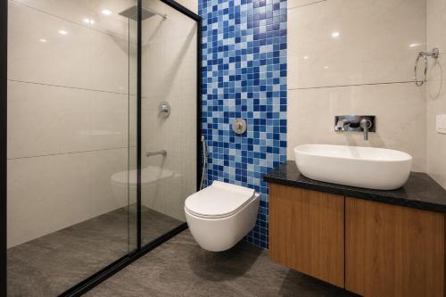 a bathroom with a toilet and a sink and a shower at Bungalow Seven Mount Abu in Mount Ābu