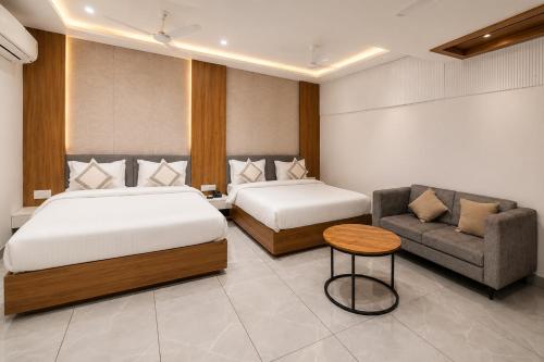 a hotel room with two beds and a couch at Bungalow Seven Mount Abu in Mount Ābu