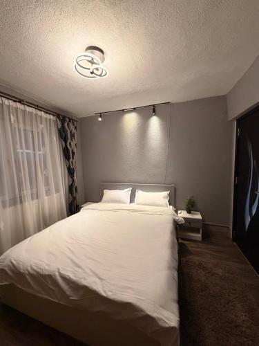 a bedroom with a large bed with white sheets at Modern Panoramic View Apartament in Sighetu Marmaţiei