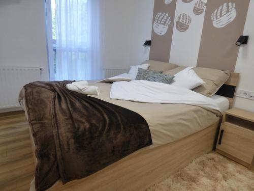 a large bed with a blanket on it in a bedroom at Pogácsás Apartman III in Tokaj