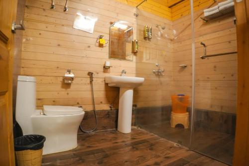 a bathroom with a toilet and a sink and a shower at White Petals Resort in Bangalore