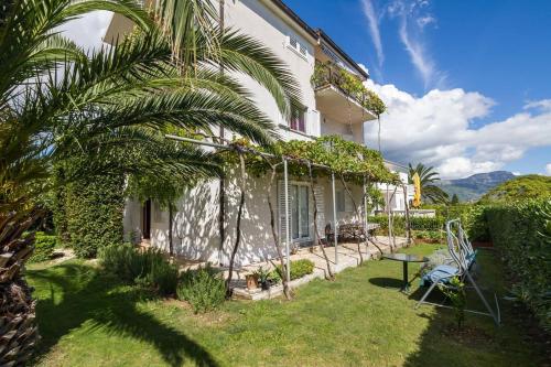 a house with a palm tree in the yard at Hostel Oktarin in Kaštela