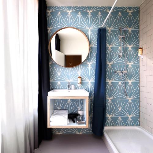 a bathroom with a sink and a mirror on a wall at Vintage Hotel Brussels in Brussels