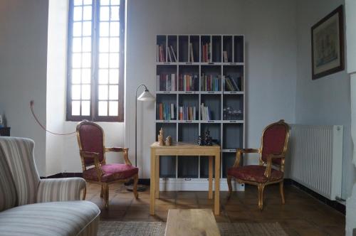 a living room with a book shelf filled with books at Le Vieux Château de Saint Martin-Lars in Saint-Martin-Lars-en-Sainte-Hermine