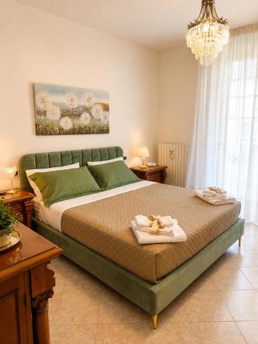 a bedroom with a green bed with two towels on it at Lo Zio Vito in Porto San Giorgio