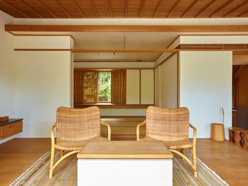 two rattan chairs and a table in a room at Numazu Club in Numazu