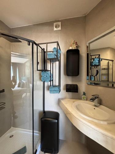 a bathroom with a sink and a glass shower at Bela Vista Suites in Carvoeiro