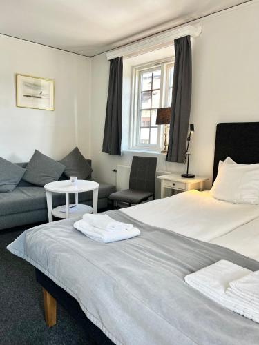 a hotel room with a bed and a couch at Värdshuset Hwitan in Falkenberg
