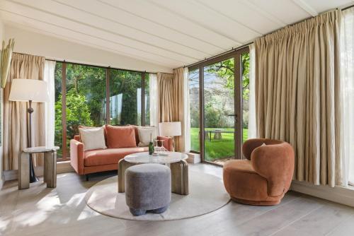 a living room with furniture and large windows at Château de la Gaude in Aix-en-Provence