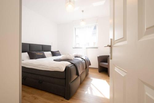 a bedroom with a bed in a white room at eifel5starIV Burgfriedstraße in Daun