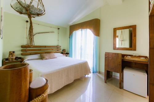 a bedroom with a bed and a desk and a mirror at Oasi Scolacium in Villaggio Le Rocelle