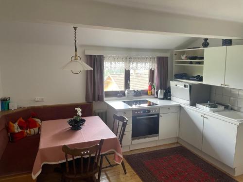 a kitchen with a table with a pink table cloth at Pension Victoria in Millstatt