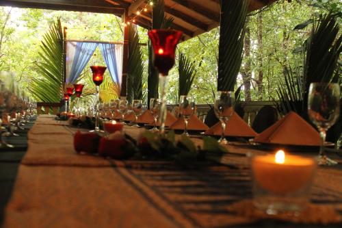 a long table with candles and wine glasses on it at Permai Rainforest Resort in Santubong