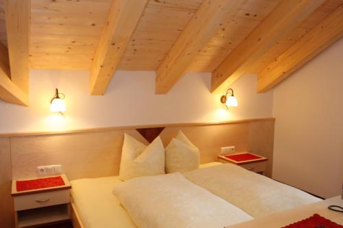 a bedroom with a bed with two lights on it at Haflingerhof in Fiss