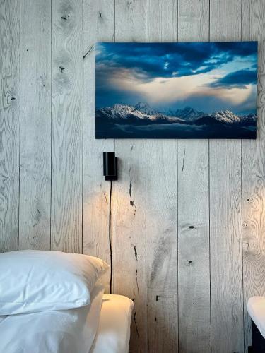a bedroom with a bed and a painting on the wall at Reinefjorden Sjøhus in Reine