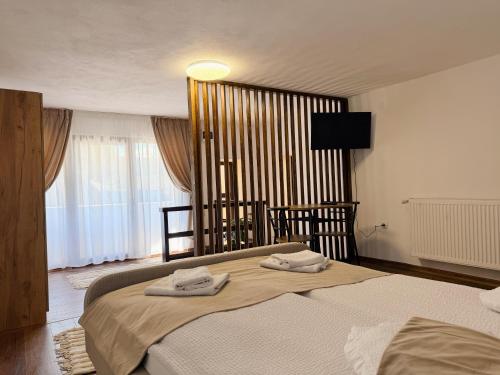 a bedroom with a large bed with towels on it at Casa ZUGO in Borsec