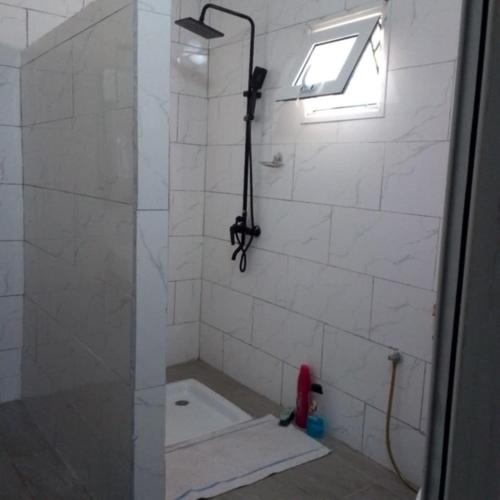a bathroom with a shower with a glass door at villa Moissuli par chambre in Mtsamboro