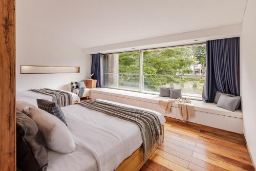 two beds in a room with a window at TTR Rin Villa & Hotel in Da Lat