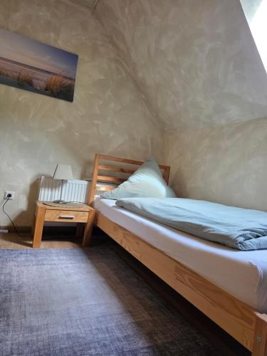a bedroom with a bed and a table with a lamp at Fuchs & Hase in Uplengen