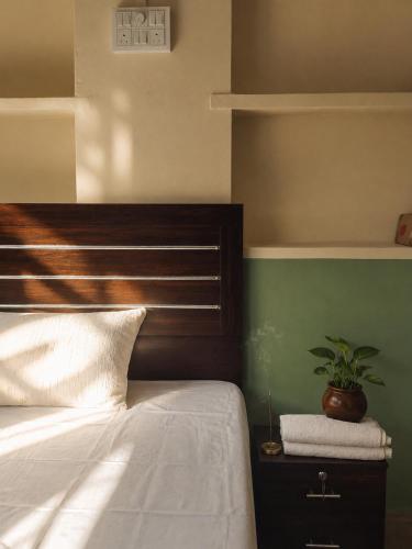 a bedroom with a bed and a plant on a night stand at Shristays in Varanasi
