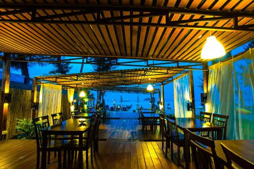 a restaurant with tables and chairs on a deck at Salisa Resort in Ko Lipe