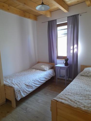 a bedroom with two twin beds and a window at Przystanek Bereżnica in Bereżnica Wyżna