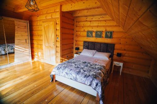 a bedroom with a bed in a wooden cabin at Leśna Oaza in Sierpc
