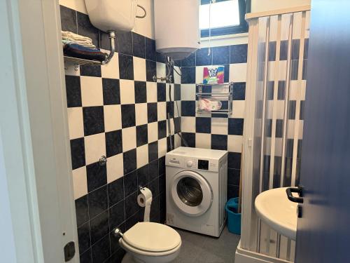a bathroom with a washing machine and a toilet at Anno Zero Sweet House in Stazione di San Sostene