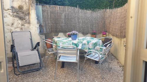 a table and chairs with a table and a fence at Maison clara 2 rue du centre in Clara