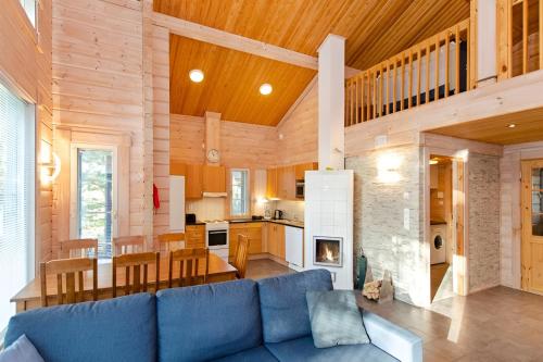 a living room and kitchen with a blue couch in a house at Kolin Lotus Superior-Amero Cottages in Kolinkylä