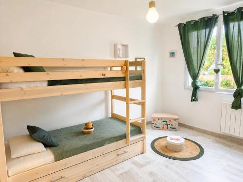 a bedroom with two bunk beds and a window at Séjour bercé par la Mer in Jard-sur-Mer