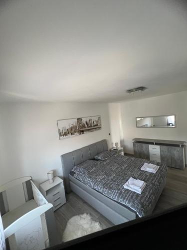 a small bedroom with a bed and a chair at Apartman Ariana in Ližnjan