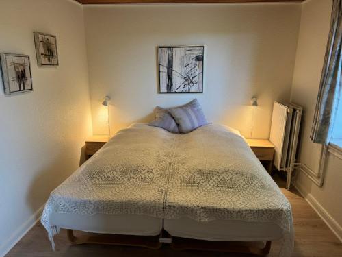 a bedroom with a bed with two lamps on two tables at Henne Strand Ferie Accommodation in Hennebjerg
