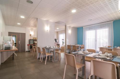 une salle à manger avec des tables et des chaises dans un restaurant dans l'établissement Appart'City Confort Perpignan Centre Gare, à Perpignan