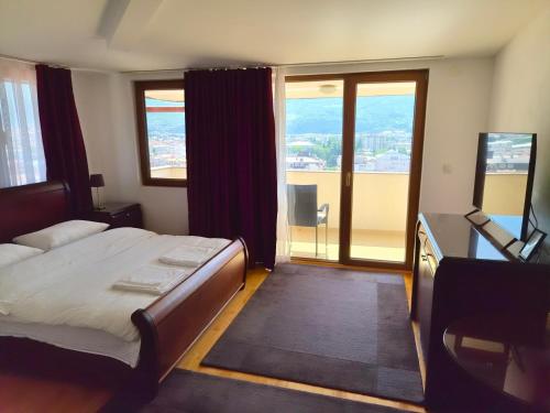 a bedroom with a bed and a desk with a television at Villa Bella in Ohrid