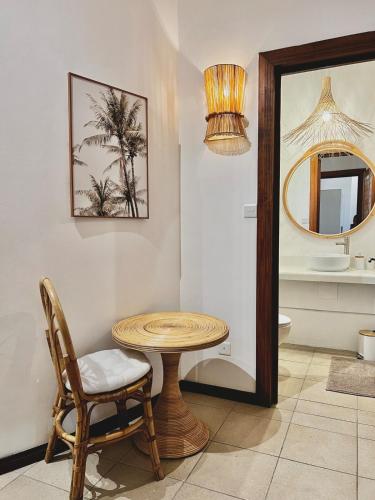 a room with a table and a chair and a mirror at Little Palm Penthouse in Cap Malheureux