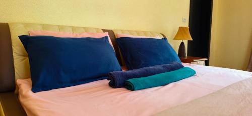 a bed with blue and green pillows on it at Luxury Beachfront SeaView Apartment in Ko Chang