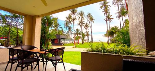 a table and chairs on a porch with a view of the ocean at Luxury Beachfront SeaView Apartment in Ko Chang