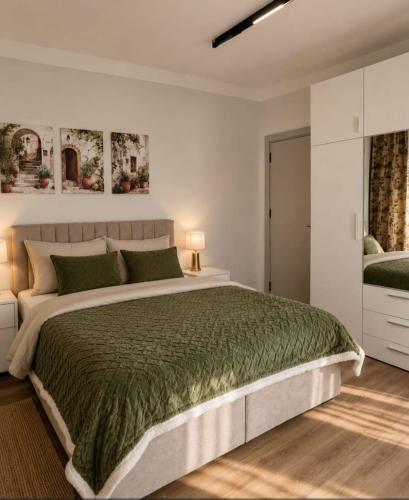 a bedroom with a large bed with a green bedspread at Villa AdriaBelle in Tivat
