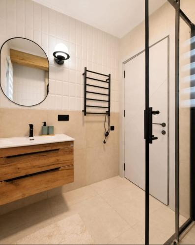 a bathroom with a sink and a mirror and a shower at Villa AdriaBelle in Tivat