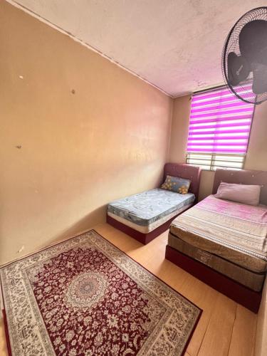 a bedroom with two twin beds and a window at D Anggun Homestay in Kampung Gurun