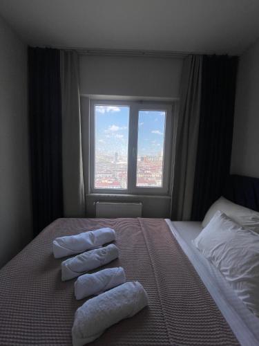 a hotel room with towels on a bed with a window at Classic Suite BH13 in Esenyurt